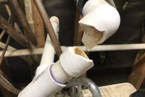 A busted PVC water pipe with ice frozen and water dripping in Mascoutah, Illinois.