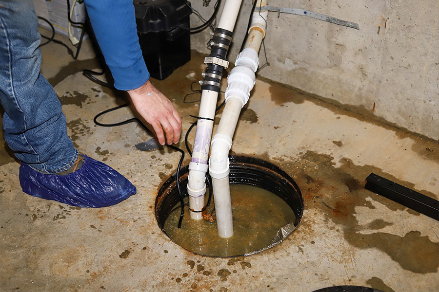 A residential sump pump that is overflowing and being pumped by a quality plumbing and sewage technician in Belleville, IL.